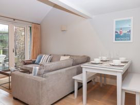 A living room with a sofa and dining table at 3 Keepers Cottage