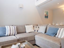 A sofa with cushions and a coffee table in a living room at 3 Keepers Cottage