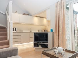 A kitchen area with a television and tea set at 3 Keepers Cottage