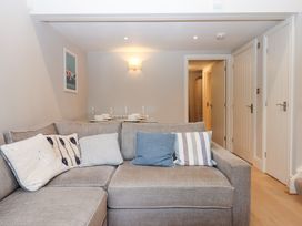 A living room with a sofa and dining table at 3 Keepers Cottage