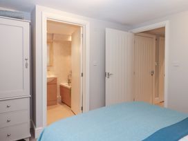 A bedroom showing a wardrobe and doors leading to a bathroom at 3 Keepers Cottage