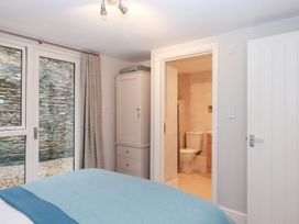 A bedroom with a wardrobe and a bathroom door at 3 Keepers Cottage