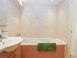 A bathroom with a bathtub and sink at 3 Keepers Cottage