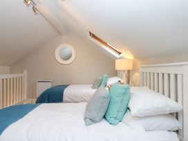 A bedroom with two beds and a lamp at 3 Keepers Cottage 