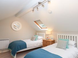A bedroom with twin beds and a skylight at 3 Keepers Cottage