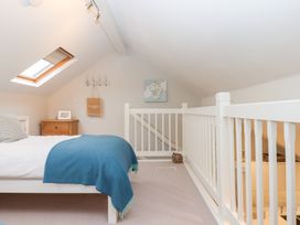 A loft with a bed and nightstand at 3 Keepers Cottage