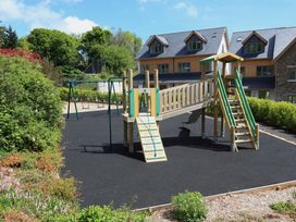 A playground with climbing frame and swing set at 3 Keepers Cottage