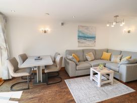 A living room with a sofa and dining area at 3 Keepers Cottage, Hillfield Village