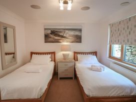 A bedroom with twin beds and a bedside table at 3 Keepers Cottage, Hillfield Village near Dartmouth