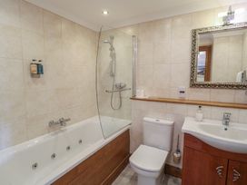 A bathroom with a bathtub, shower, toilet, and sink at 3 Keepers Cottage, Hillfield Village