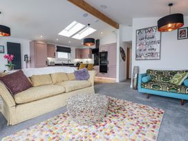 A living room with sofas and kitchen units at Minack Lodge in Redruth