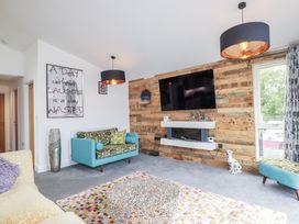 A living room with a sofa and television at Minack Lodge in Redruth