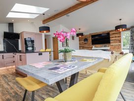 A living room with kitchen area and a table at Minack Lodge in Redruth