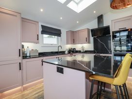 A kitchen with cabinets and an island at Minack Lodge Redruth