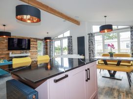 A kitchen with a dining table and bar stools at Minack Lodge in Redruth