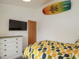A bedroom with a bed and dresser at Minack Lodge in Redruth