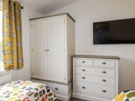 A bedroom with a wardrobe and chest of drawers at Minack Lodge in Redruth
