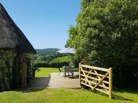 An outdoor area with a wooden deck and furniture at Tapps Lodge Brixton near Yealmpton, South Devon