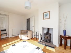 A living room with a wood stove and table at Tapps Lodge in Brixton near Yealmpton, South Devon