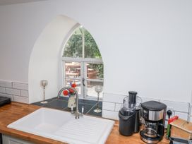 A kitchen with a sink and window at Tapps Lodge Brixton near Yealmpton, South Devon