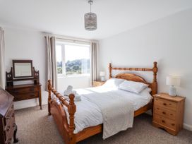 A bedroom with a bed and dresser at Tapps Lodge Brixton near Yealmpton, South Devon