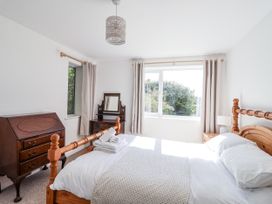A bedroom with a bed and window at Tapps Lodge in Brixton near Yealmpton, South Devon