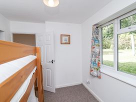 A bedroom with a bunk bed and window at Tapps Lodge in Brixton near Yealmpton, South Devon