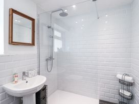 A bathroom with a shower, sink, and towels at Tapps Lodge Brixton near Yealmpton, South Devon