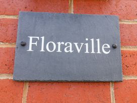 A slate sign with the name Floraville on a brick wall