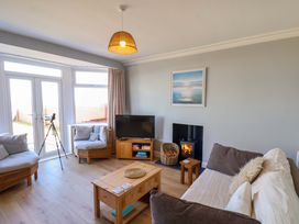 A living room with a sofa, coffee table, and television at Floraville