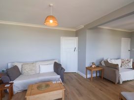 A living room with sofas and a wooden table at Floraville