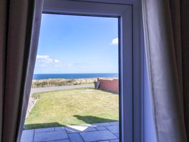 A view of the sea and lawn through a window at Floraville