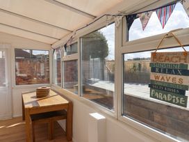 A conservatory with a wooden table and chairs at Floraville