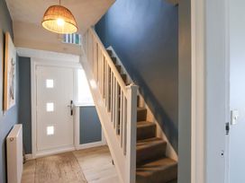 A hallway with a staircase and front door at Floraville