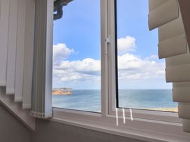 A window with blinds overlooking the ocean at Floraville