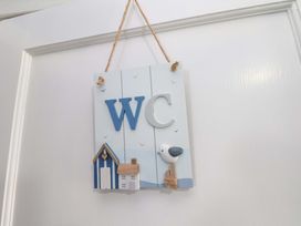 A WC sign with a bird and beach house decorations at Floraville