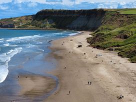 A beach with people and cliffs at Floraville in Cayton Bay