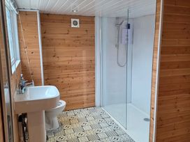A bathroom with a shower, sink, and toilet at Floraville in Cayton Bay