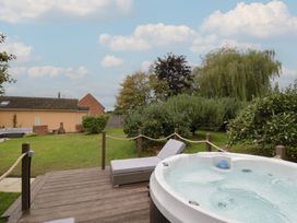 A garden with a hot tub and sun lounger at Harran in Pershore