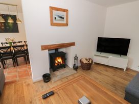 A living room with a fireplace and TV at Harran in Pershore