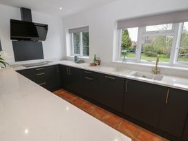 A kitchen with black cabinets and a sink at Harran in Pershore