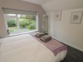 A bedroom with a window and mirror at Harran in Pershore