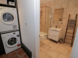 A laundry room with washing machine and shower at Harran in Pershore
