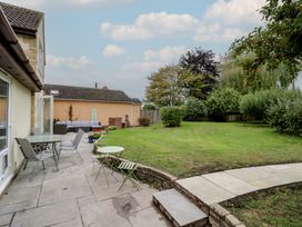 A garden with a patio table and seating area at Harran in Pershore