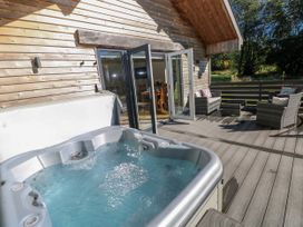 An outdoor area with a hot tub and seating at Dwrgi Llanybydder