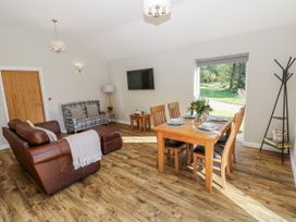 A living room with a sofa and dining area at Dwrgi in Llanybydder