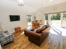 A living room with a sofa and dining table at Dwrgi in Llanybydder
