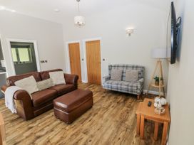 A living room with a sofa and ottoman at Dwrgi in Llanybydder