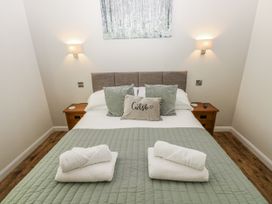 A bedroom with a bed and bedside table at Dwrgi in Llanybydder