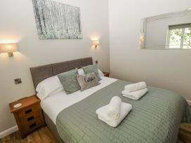 A bedroom with a bed and bedside tables at Dwrgi in Llanybydder